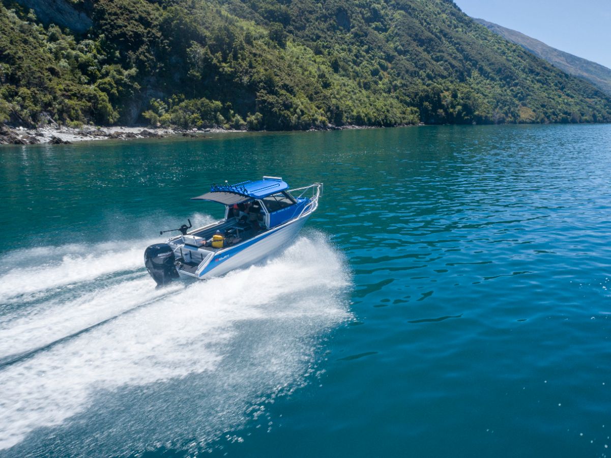 small blue McLay 661 CrossXover Hardtop crossing through a shallow water